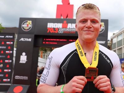 Jack Scott Ramsay is posing for the picture while holding the medal.